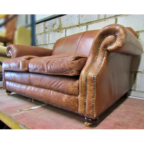 1494 - A small traditional leather two seat sofa with scrolled arms, 150cm wide