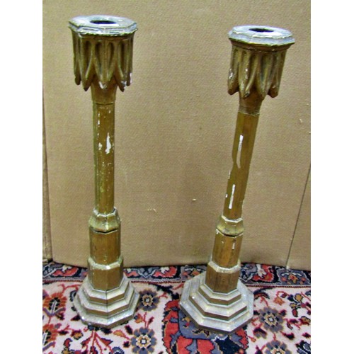 1424 - Pair of giltwood candlesticks in the Gothic manner with lead weighted bases, 56cm high