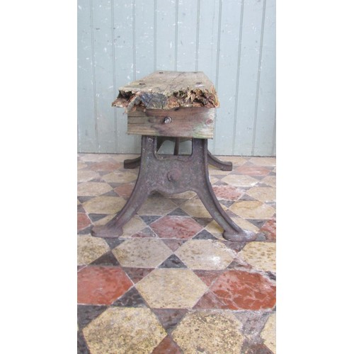 1059 - An antique cast iron bench base with swept supports united by a simple steel rod beneath an associat... 