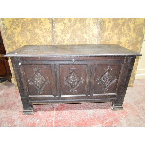 1557 - An antique oak coffer, the three panelled front with geometric carved detail, 76cm high x 138cm wide... 