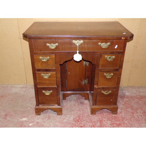 1559 - A Georgian style mahogany and oak lined kneehole desk or eight drawers and central cupboard, 77cm hi... 