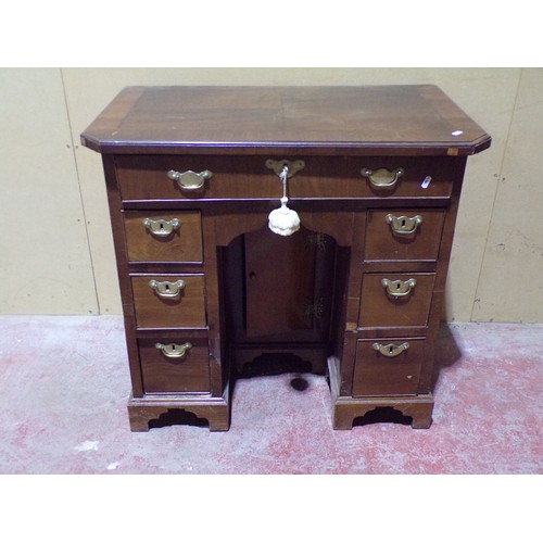 1559 - A Georgian style mahogany and oak lined kneehole desk or eight drawers and central cupboard, 77cm hi... 