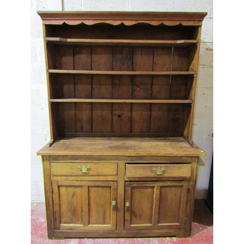 1568 - A rustic oak country made oak kitchen dresser, the base enclosed by a pair of panelled doors and fri... 