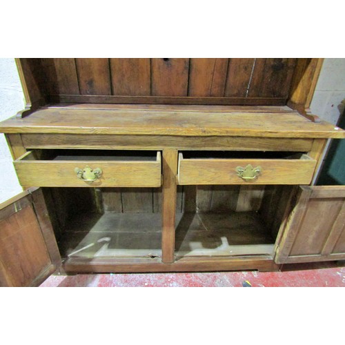 1568 - A rustic oak country made oak kitchen dresser, the base enclosed by a pair of panelled doors and fri... 