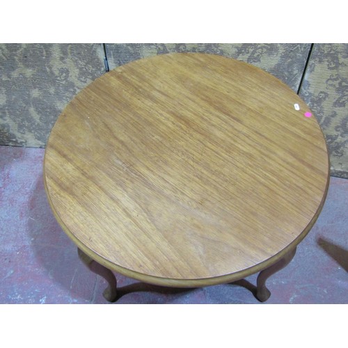 1570 - A circular teakwood table on shaped supports, 55cm high x 80cm diameter