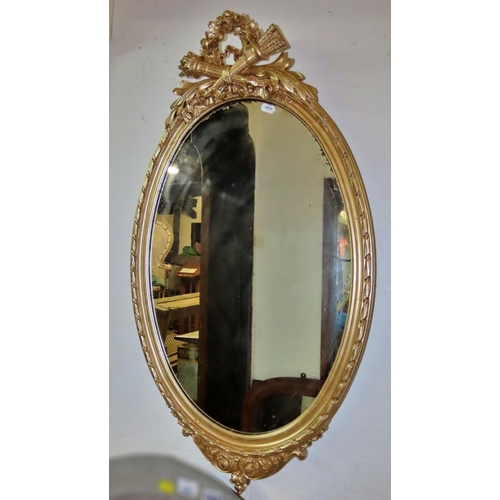 1311 - An oval gilt framed wall mirror, with classical flaming torch, quiver and floral decoration, 86cm x ... 