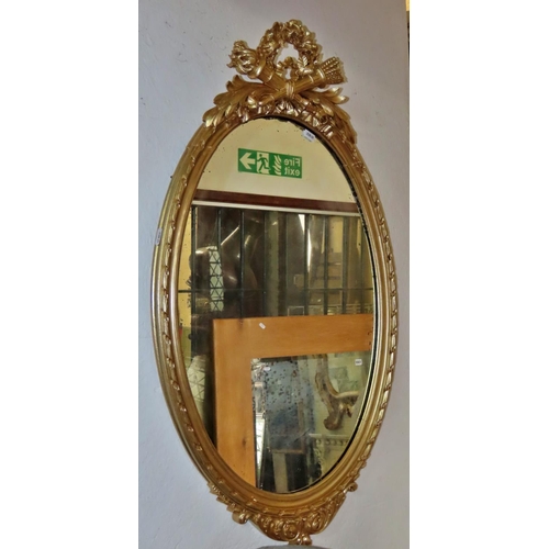 1311 - An oval gilt framed wall mirror, with classical flaming torch, quiver and floral decoration, 86cm x ... 