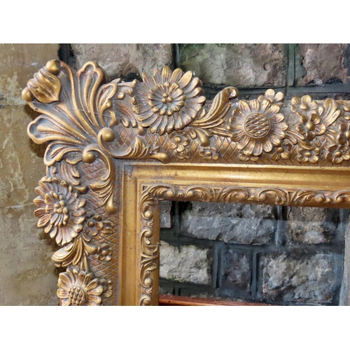 1316 - A large contemporary gilt mirror or picture frame, with foliate detail, 142cm x 116cm approx