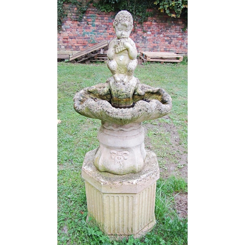 1023 - A weathered cast composition stone bird bath in the form of a shell with pan surmount and raised on ... 