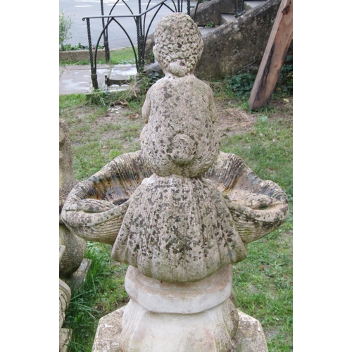 1023 - A weathered cast composition stone bird bath in the form of a shell with pan surmount and raised on ... 