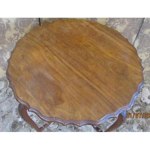 1333 - An Edwardian mahogany occasional table the circular top with serpentine moulded outline raised on sl... 