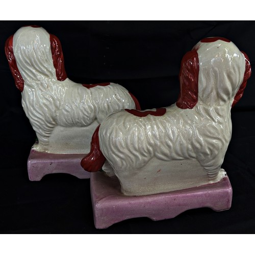 111 - A decorative pair of Staffordshire models of standing spaniels, each 25cm high, 20cm wide.