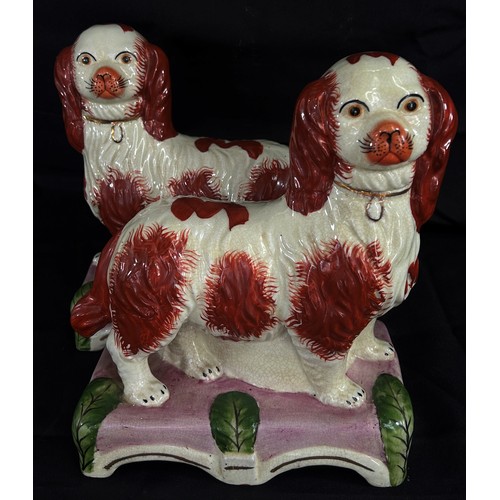 111 - A decorative pair of Staffordshire models of standing spaniels, each 25cm high, 20cm wide.