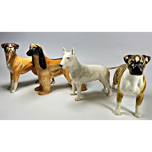 26 - Seven ceramic figures of Beswick and Royal Doulton dogs in various poses including a Black Labrador,... 