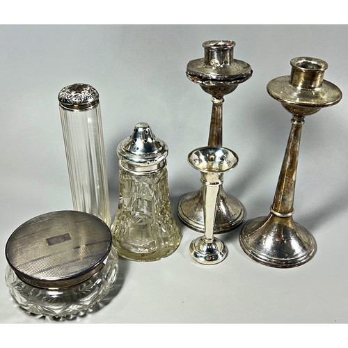 303 - A pair of silver candlesticks, a silver posy vase, a sugar caster, and two glass vanity jars with si... 