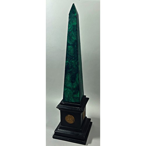 643 - An early 20th Century plaster obelisk with green malachite painted finish on a black plinth decorate... 