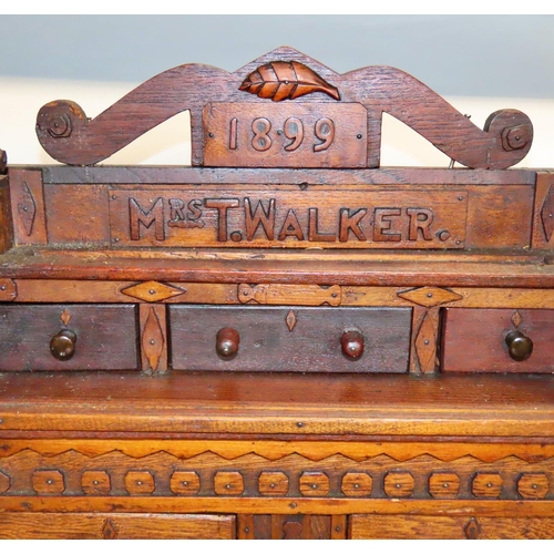 622 - A 19th century oak apprentice chest of drawers, dated 1899 to a Mrs T Walker, with a row three friez... 