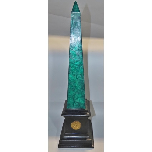 643 - An early 20th Century plaster obelisk with green malachite painted finish on a black plinth decorate... 