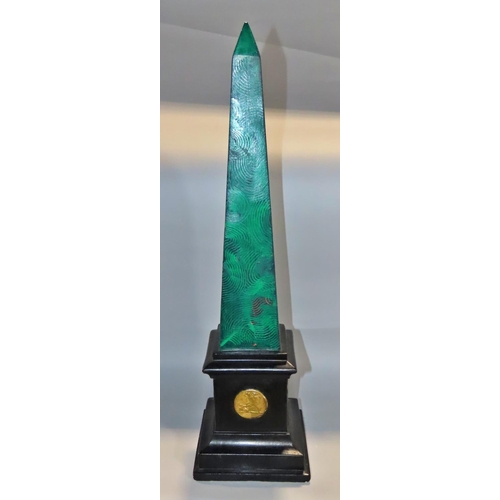 643 - An early 20th Century plaster obelisk with green malachite painted finish on a black plinth decorate... 