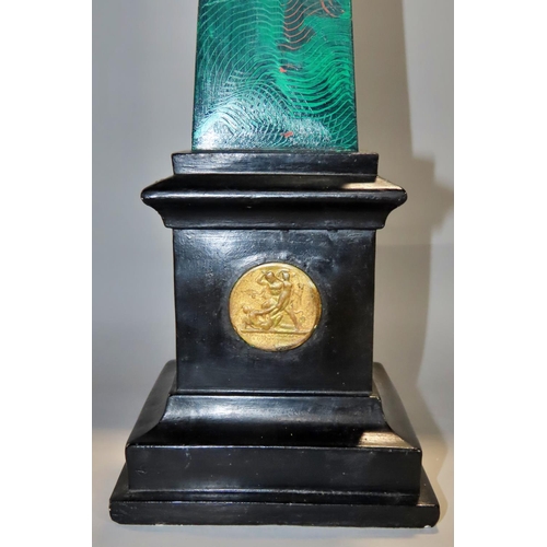 643 - An early 20th Century plaster obelisk with green malachite painted finish on a black plinth decorate... 