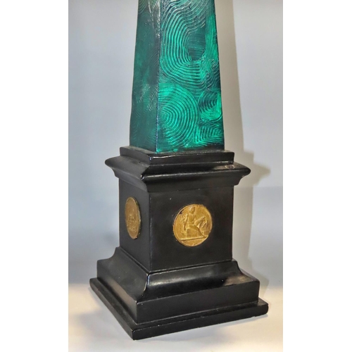 643 - An early 20th Century plaster obelisk with green malachite painted finish on a black plinth decorate... 