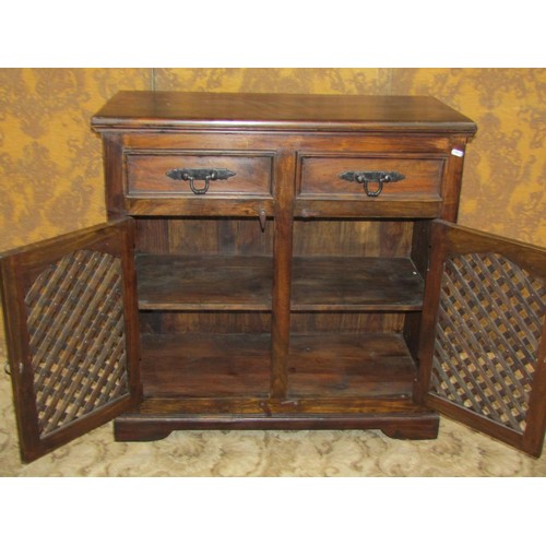 1338 - A small Indian hardwood dresser enclosed by a pair of arched lattice panelled doors beneath two frie... 