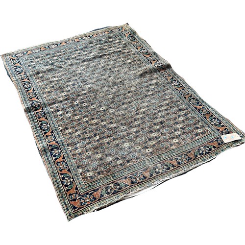 1740 - An old worn and faded Persian carpet with an all over floral pattern, 170cm x 120cm