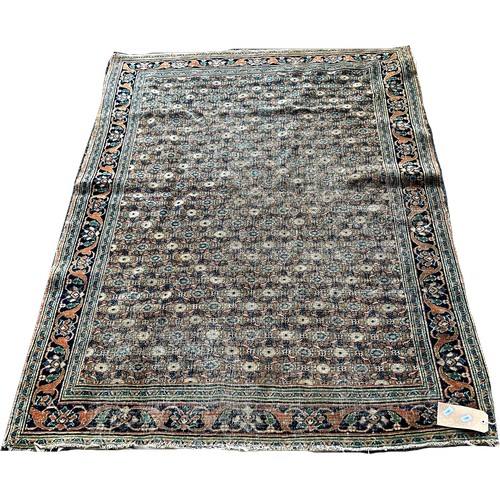 1740 - An old worn and faded Persian carpet with an all over floral pattern, 170cm x 120cm