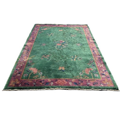 1742 - A Chinese design carpet with sprays of flowers on an ever green ground and a purple border, 275cm x ... 