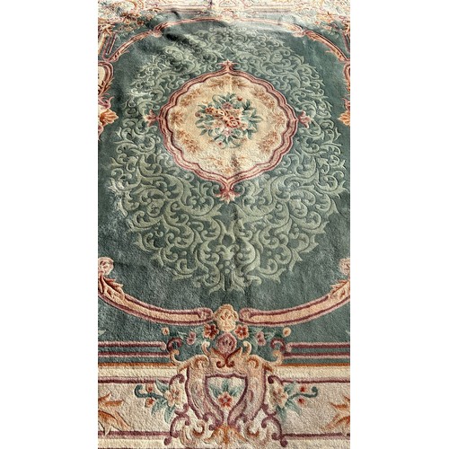 1748 - A large Chinese wool carpet with a central medallion on a green ground and floral borders, 275cm x 3... 