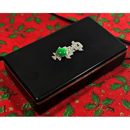 A Cartier silver and black enamel box, the hinged cover set with green jade and diamonds in the Art Deco style, enclosing a silver gilt interior, marked J C, Cartier Paris, also Made In England No 35118, import mark London 1933, length 8cm, 81g (gross weight).