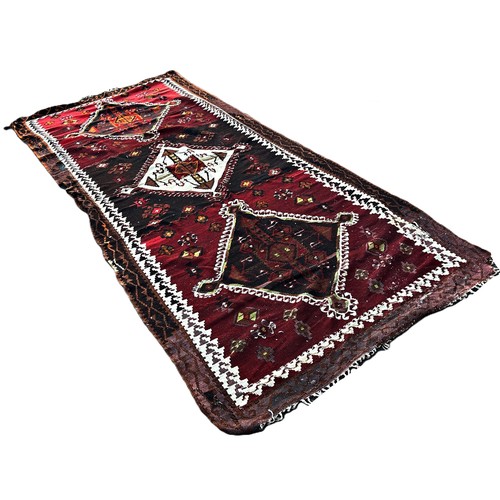 1739 - A Kilim with three large diamond shaped medallions on a dark red field.  130 x 336cm approximately