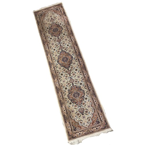 1738 - A Persian style runner  with three  circular medallions on a floral cream ground 76 x 320cm approxim... 