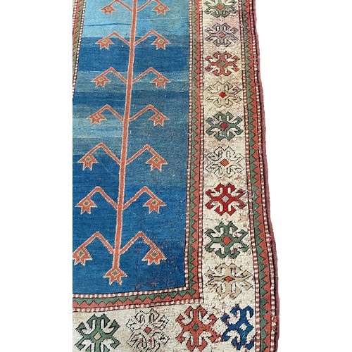 1761 - A Middle Eastern runner with a central abstract pattern on a blue ground, 400cm x 90cm approx.