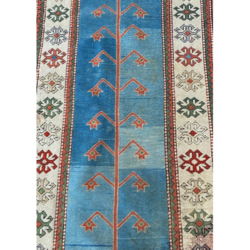 1761 - A Middle Eastern runner with a central abstract pattern on a blue ground, 400cm x 90cm approx.