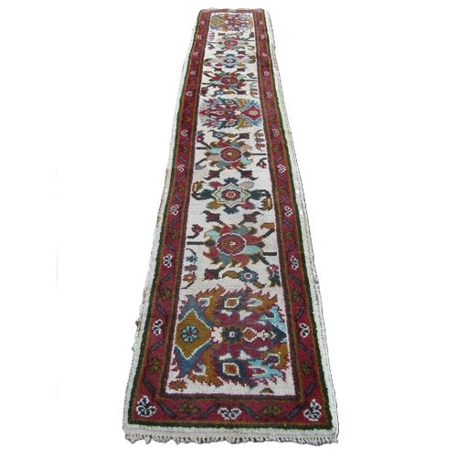 1754A - Indian wool runner, cream ground with floral detail within a running border, 370cm x 70