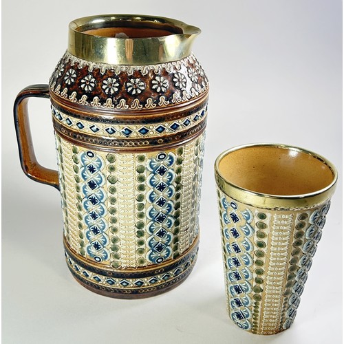 27 - A Victorian Doulton Lambeth ewer and beaker with matching geometric decoration, each with silver pla... 