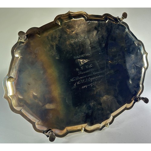 242 - A scalloped oval shaped salver engraved with a Royal Navy motor launch, with a dedication to the bas... 