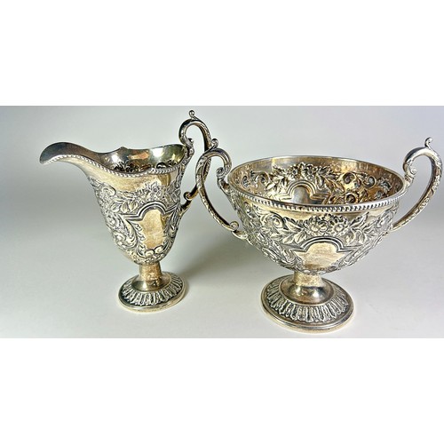 246 - A heavily engraved three piece silver tea service, with scrolling and acanthus leaf detail, Birmingh... 