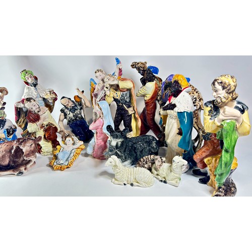 42 - An extensive Italian ceramic Nativity scene comprising sixteen pieces, all with brightly finished de... 