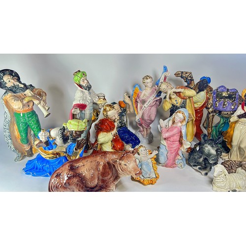 42 - An extensive Italian ceramic Nativity scene comprising sixteen pieces, all with brightly finished de... 