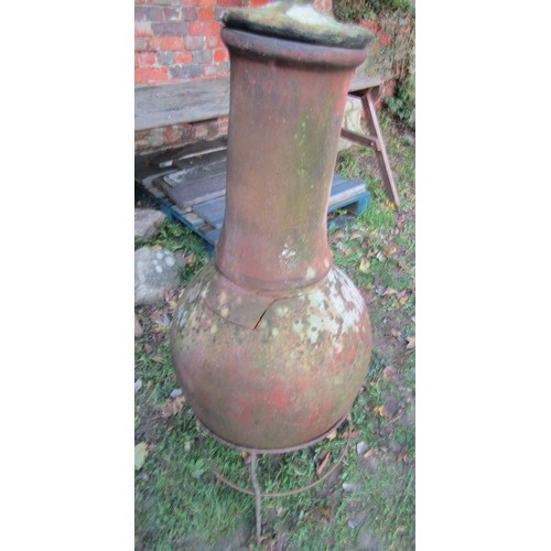 1018 - A weathered clay chiminea raised on a simple iron work stand, 110 cm high (af)