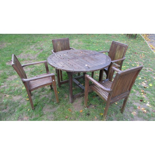 1024 - A stained and weathered  teak garden table and single bi-folding extension leaf 130 cm diameter (clo... 