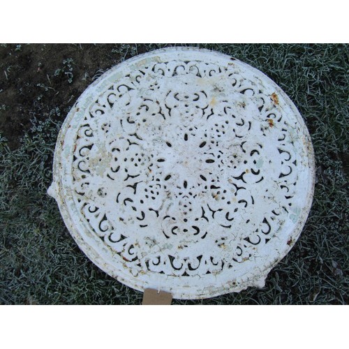 1004 - A  low circular cast iron garden table with decorative pierced top raised on three swept supports wi... 