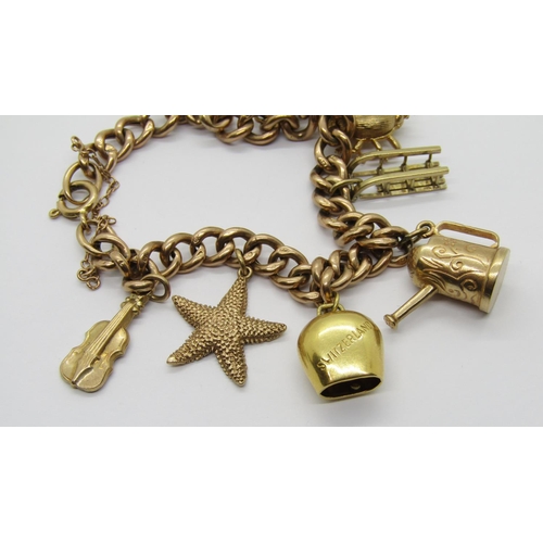 309 - 9ct curb link charm bracelet hung with eight novelty charms to include an 18ct Switzerland souvenir ... 