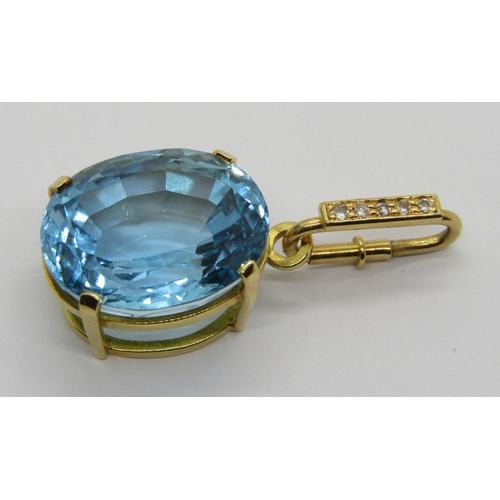 344 - Yellow metal claw set oval blue topaz pendant, the detachable diamond set bale with spring closure, ... 