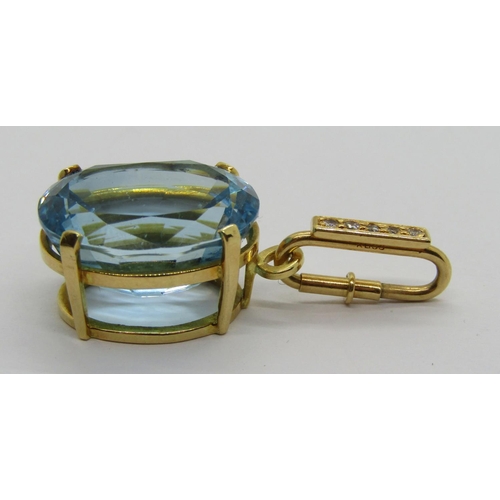 344 - Yellow metal claw set oval blue topaz pendant, the detachable diamond set bale with spring closure, ... 