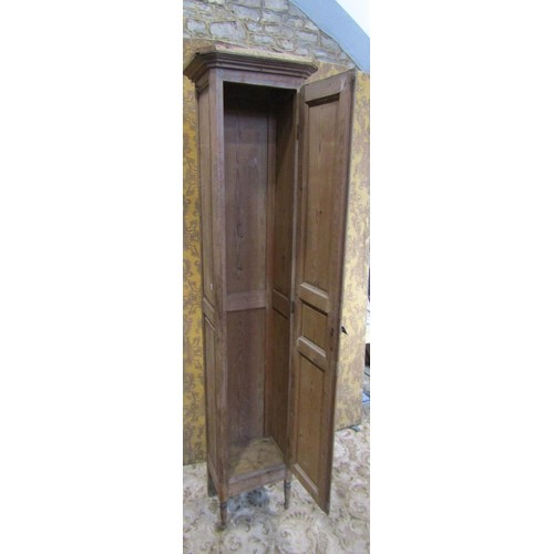 1130 - A tall narrow antique stained pine cupboard enclosed by a triple paneled door raised on turned suppo... 