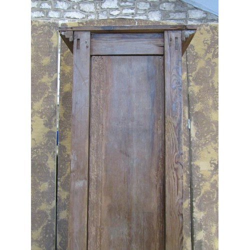 1130 - A tall narrow antique stained pine cupboard enclosed by a triple paneled door raised on turned suppo... 