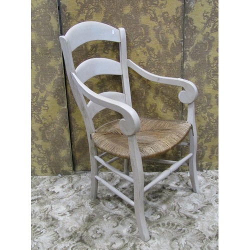 1147 - A French provincial open elbow chair with rush seat, tapered ladderback, open scrolled arms and pain... 